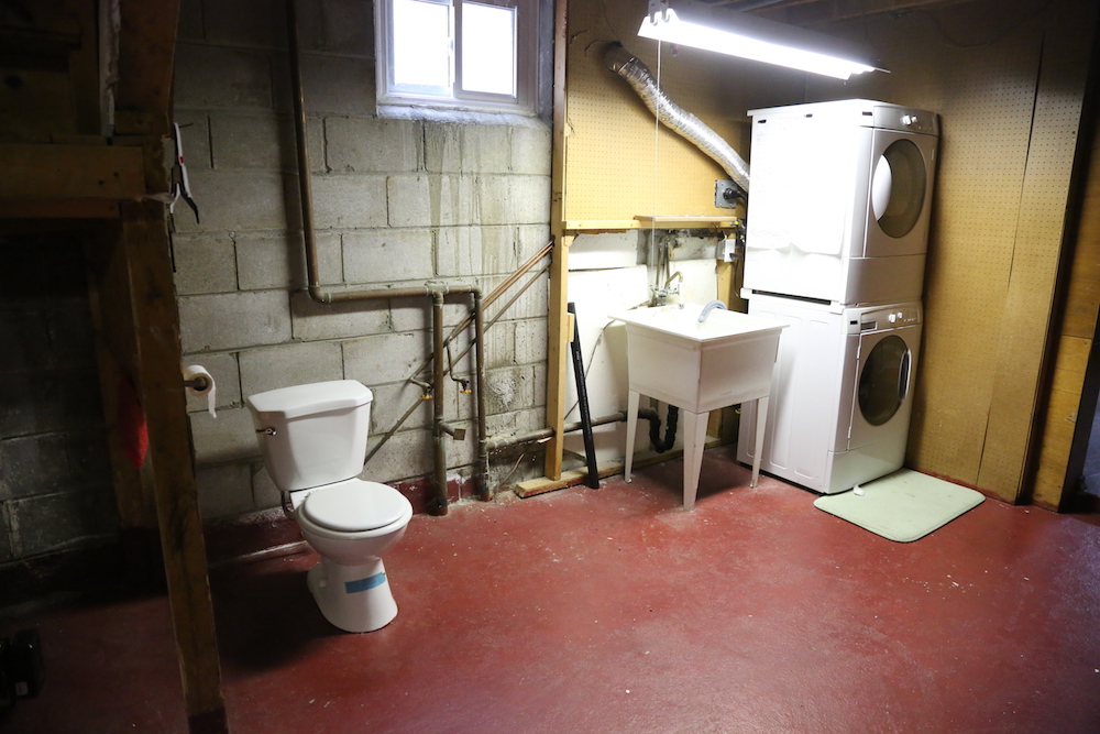 unfinished basement with red floors and white toilet