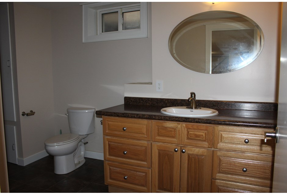 Bungalow basement bathroom with wooden cabinetry