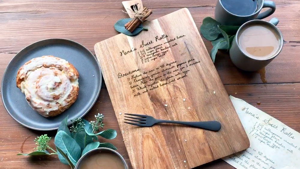 A personalized wood cutting board featuring an engraving with a family recipe