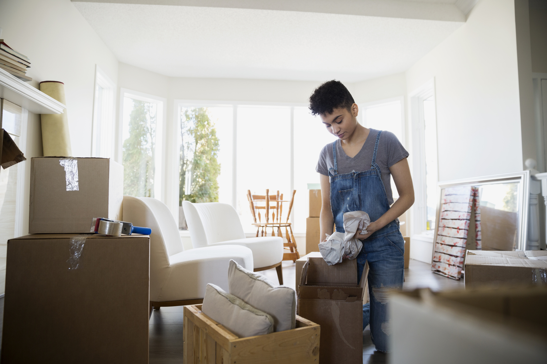Woman packing belongings in moving boxes