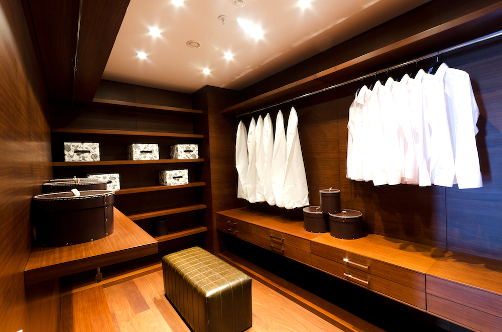 White dress shirts hanging in a walnut wood wardrobe