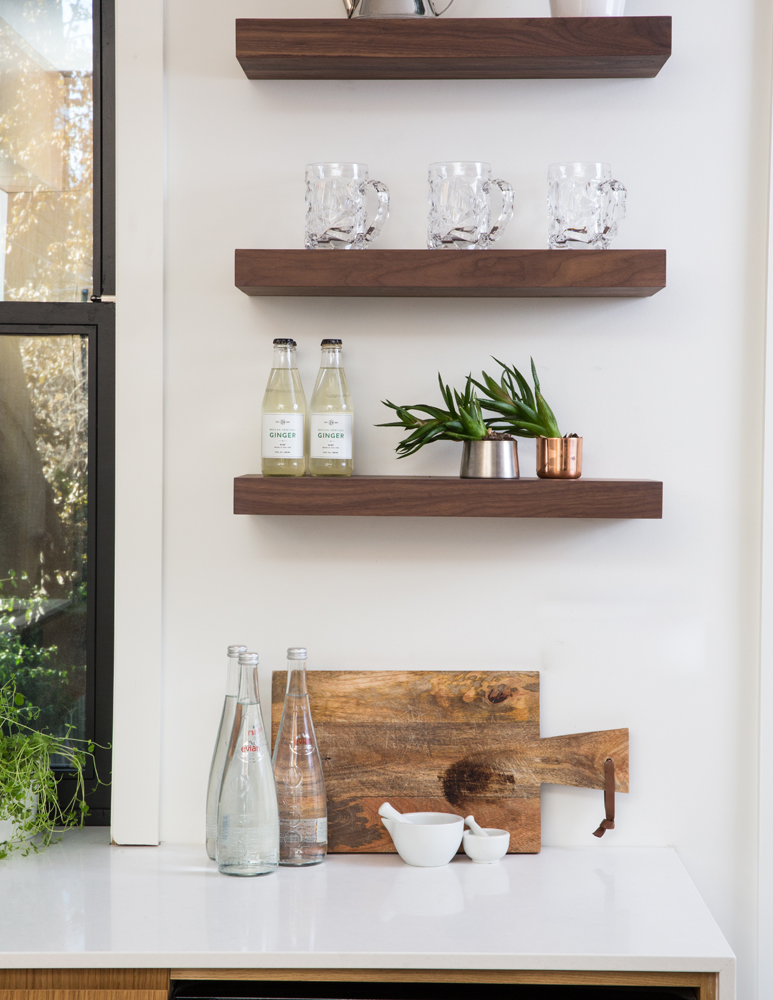 Three floating shelves above kitchen counter and cutting board