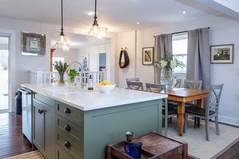 Modern farmhouse kitchen with spruce green island and two vintage inspired pendant lamps