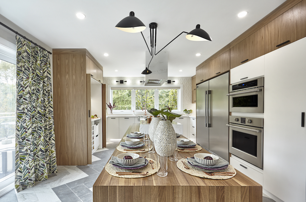 Modern kitchen full of bleached oak cabinets and sit at kitchen island set for a chic dinner