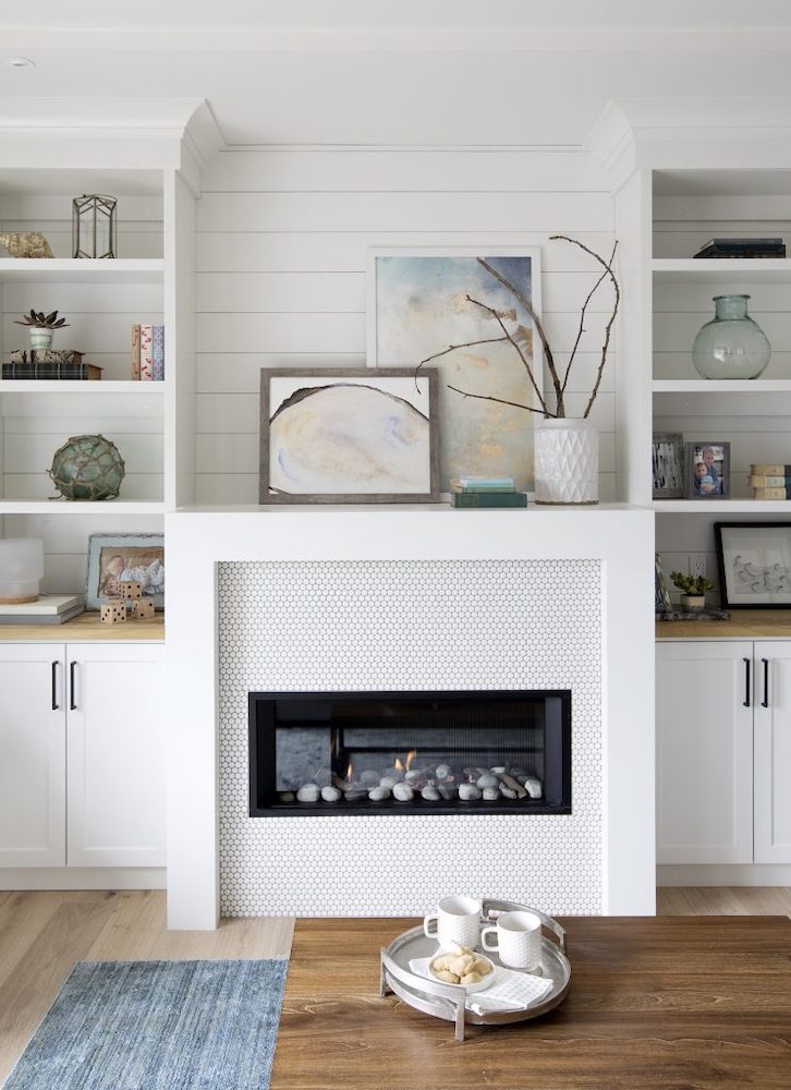 Shiplap treatment in the living room is the backdrop to a plethora of penny tiles on the fireplace.