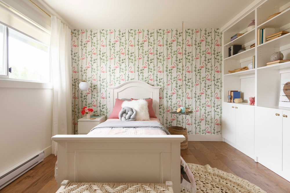 Girl's room with flamingo-print wallpaper accent wall.