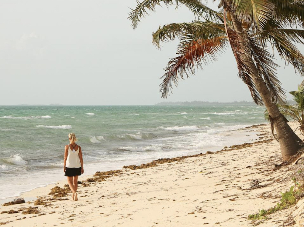 Sarah Baeumler walks down a white sand beach