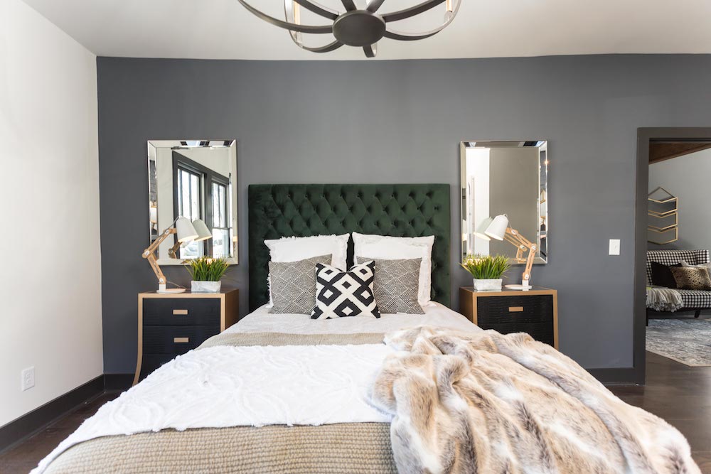 Masters of Flip luxe lodge master bedroom bed with green headboard and faux-fur throw