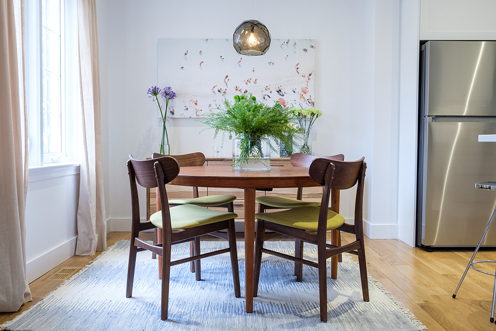 Mid century modern dining room table and chairs sit in a modern dining area