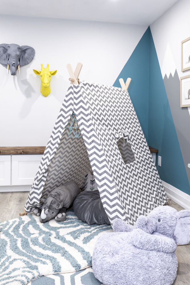 Chic basement playroom with a grey chevron play tend and zebra striped rug