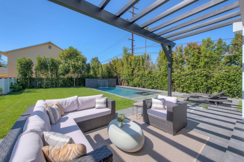 An expansive patio and sun deck with white cushioned couches