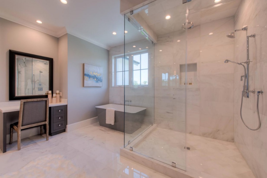 An oversized shower, soaker tub, dual-sink vanity and makeup desk in the master bathroom