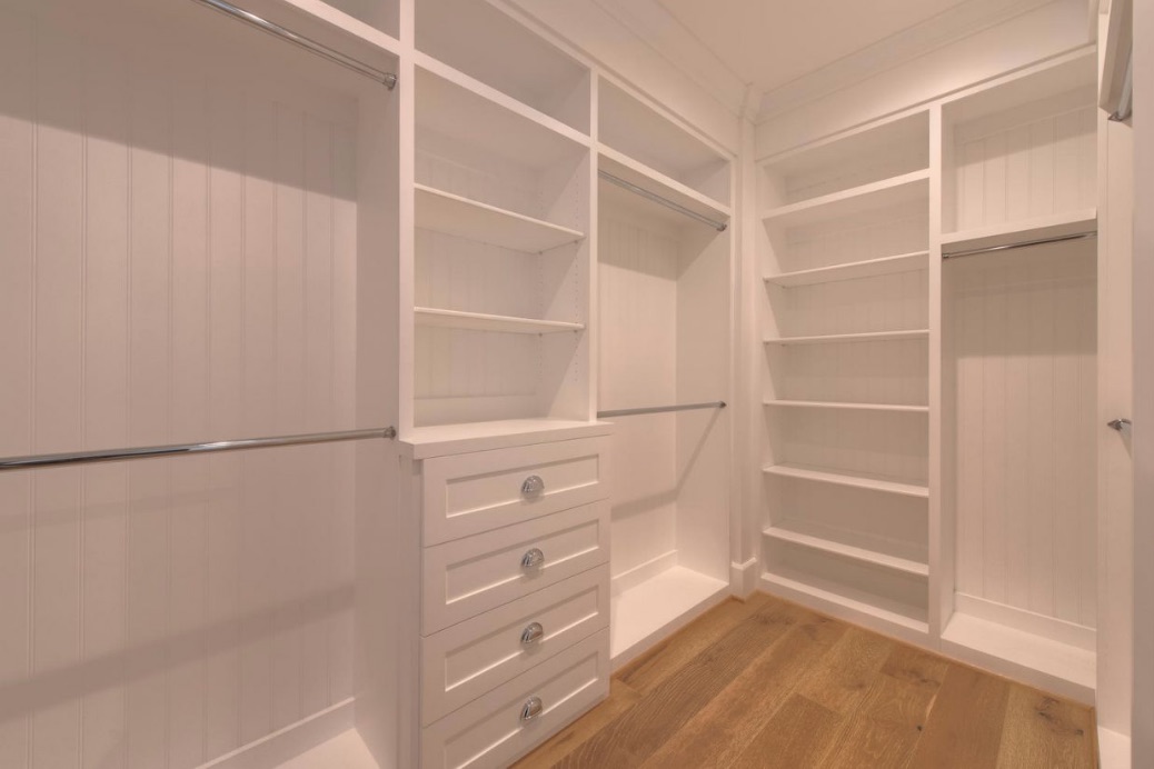 A white, empty walk-in closet with plenty of space