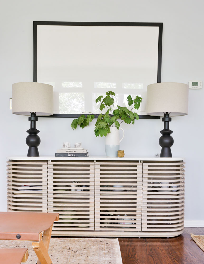 slatted console with two black based lamps on it