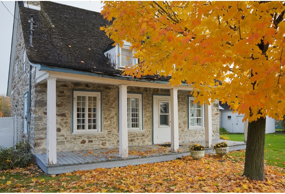 old stone house in fall setting with leaves on the ground