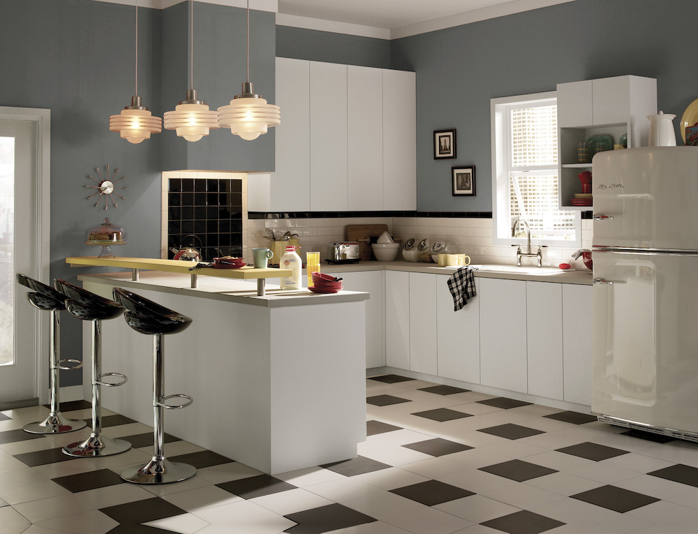 Retro inspired kitchen with white and black check floors, egg shaped barstools, white cabinets and dark grey walls painted in BEHR Mined Coal PPU18-18