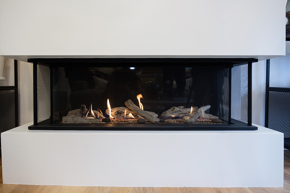 White modern gas fireplace with flaming logs