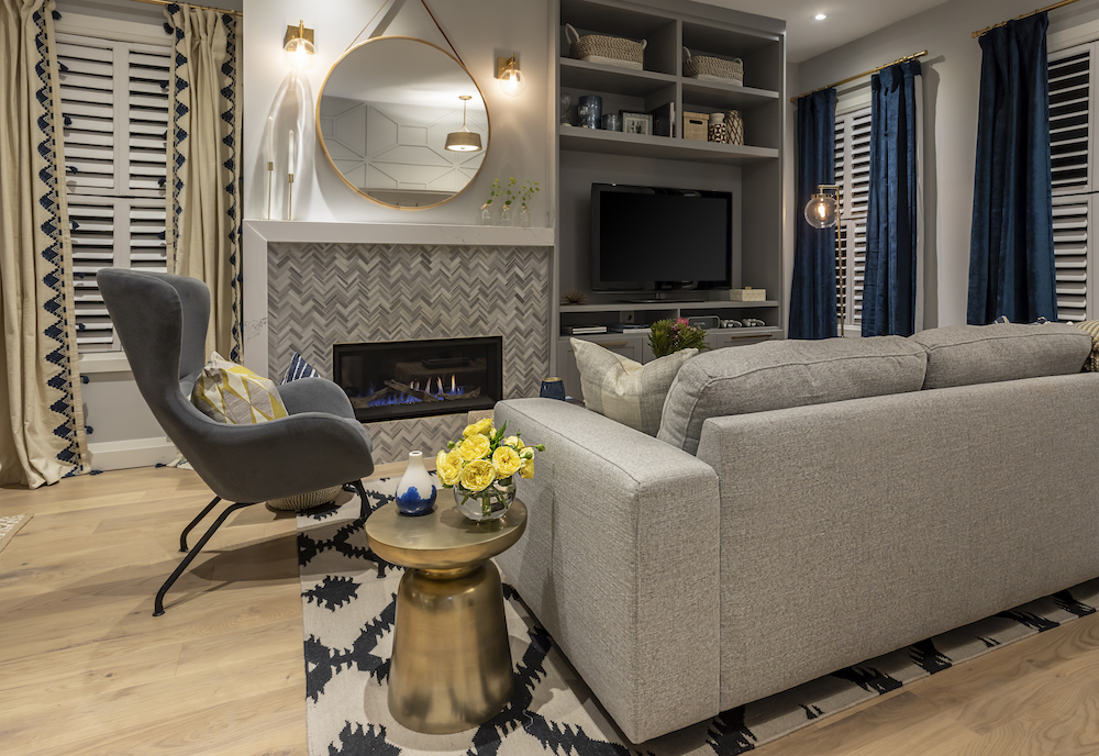 A chic gas fireplace is surrounded by trendy grey herringbone marble tile and a built in entertainment centre