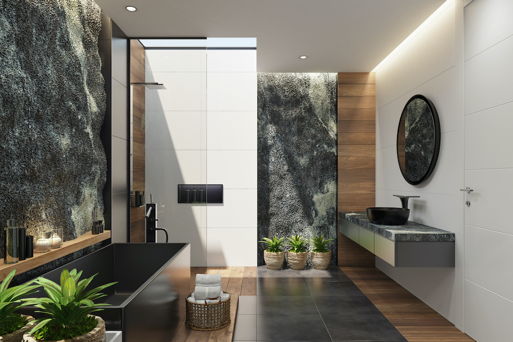 Modern bathroom with exposed rock walls, a large rectangular bathtub, wood and black tile floors, a large open shower and a floating vanity with a black vessel sink