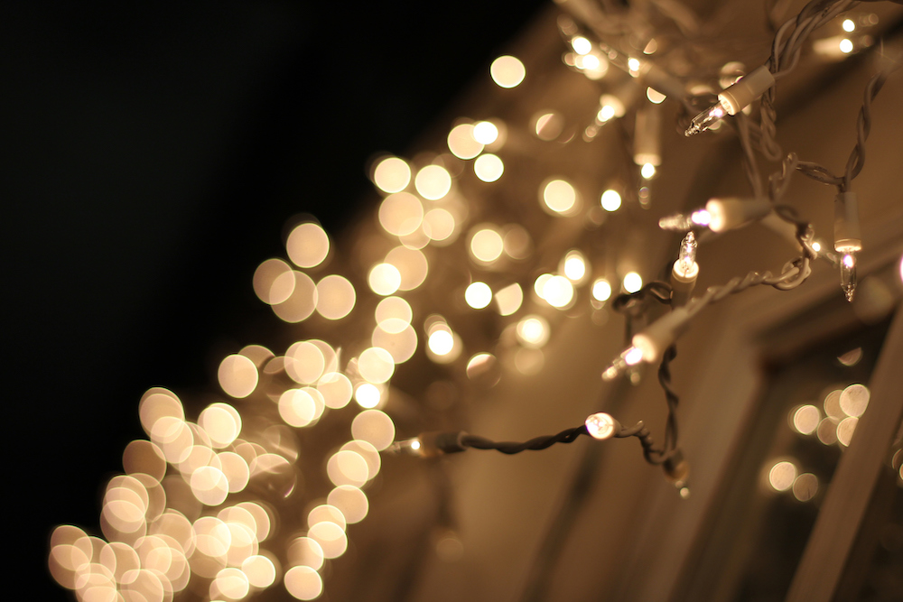 White outdoor fairy lights attached to a home’s exterior at night