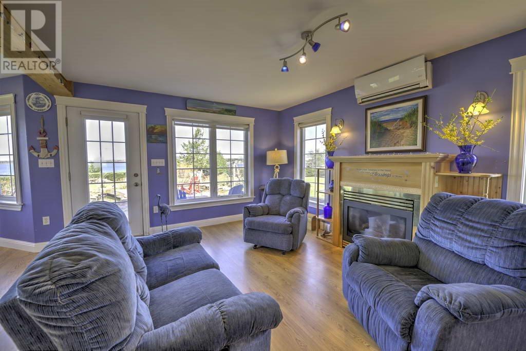 Brightly lit living room with plush furniture and lavender walls with gas fireplace