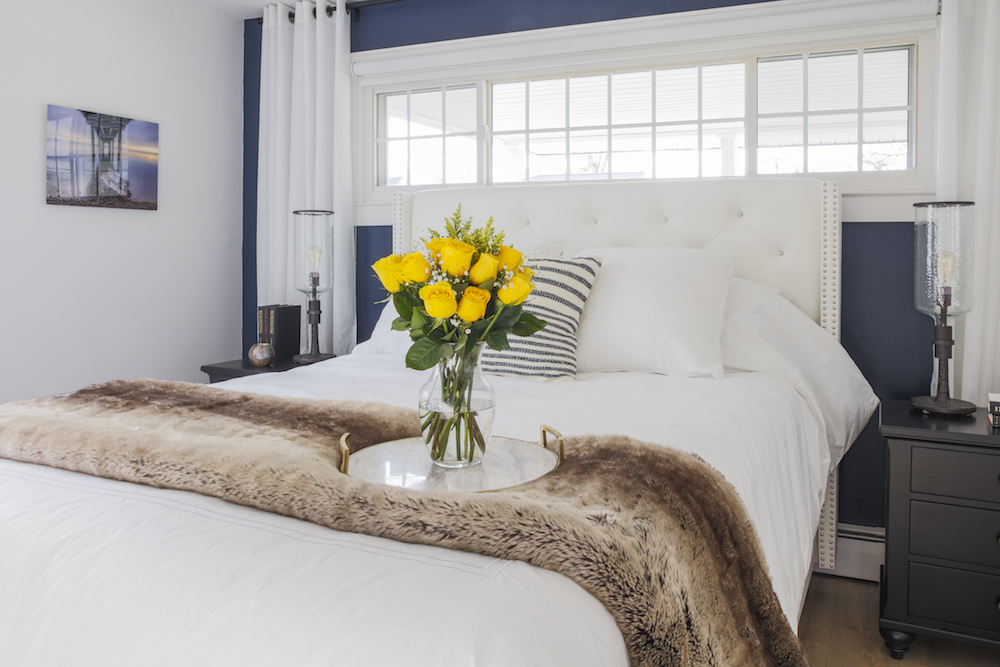 Buyers Bootcamp Cape Cod master suite white bed with yellow roses and faux fur throw