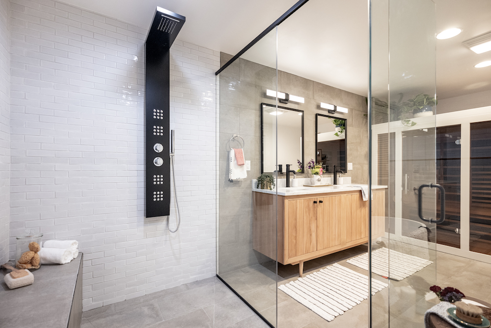 Modern bathroom with a massive walk-in shower with rainfall and multi-jet heads and wide bench, a wooden double sink vanity and a pair of black mirrors