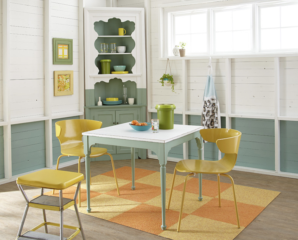 Lively dining room with green and white painted board walls, green and white table, and two yellow chairs painted with BEHR Chalk Decorate Paint in Summer Porch BCP12
