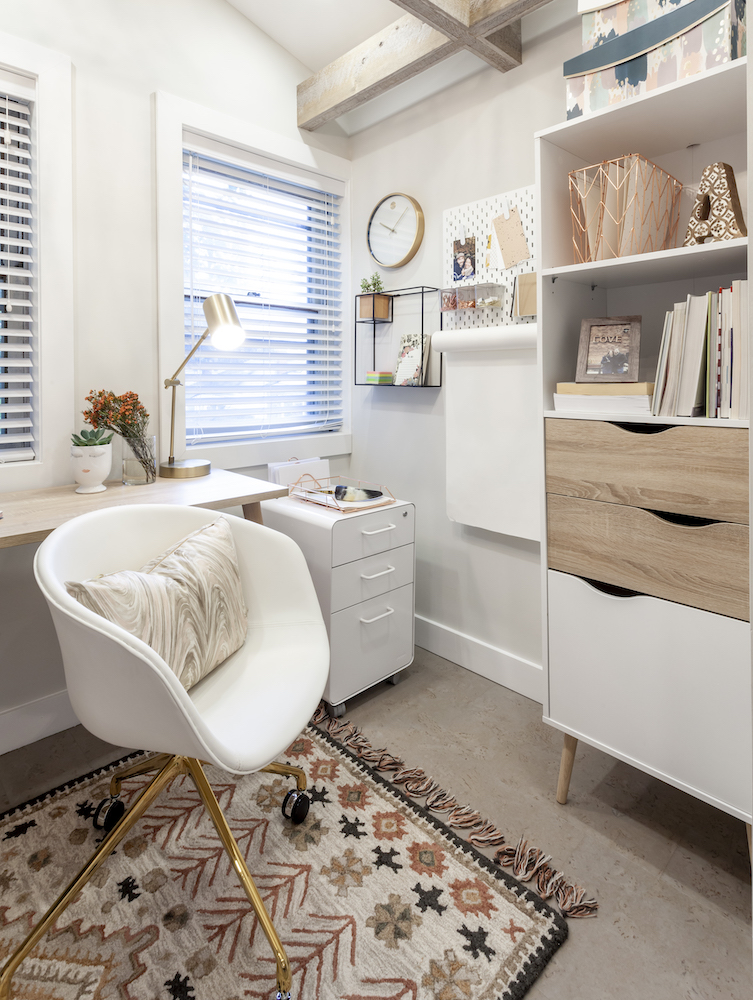 Chic Scandinavian inspired home office with white storage and patterned rug on the cork floors