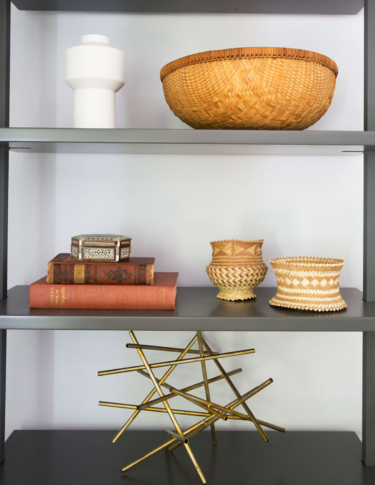 metal bookshelves with woven baskets, brass and accessories