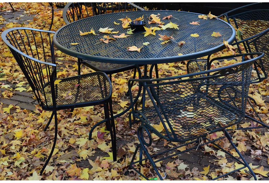 patio furniture outside covered in fallen leaves