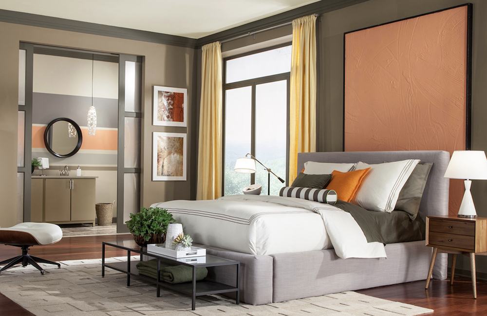 A bold modern bedroom with a large grey upholstered bed, yellow drapes and walls painted in a myriad of different shapes with BEHR Gray Squirrel N320-5, Patio Stone N360-6, Confident White GR-W12 and Trick Or Treat M220-4