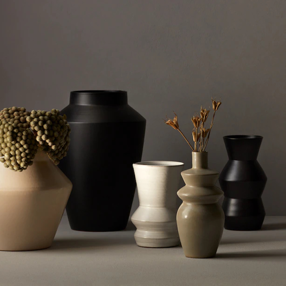 A set of Oui vases in modern matte black, tan and cream glazes on a grey background available at Chapters Indigo