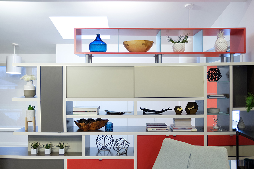 A set of shelves and cabinets with grey, white and red doors