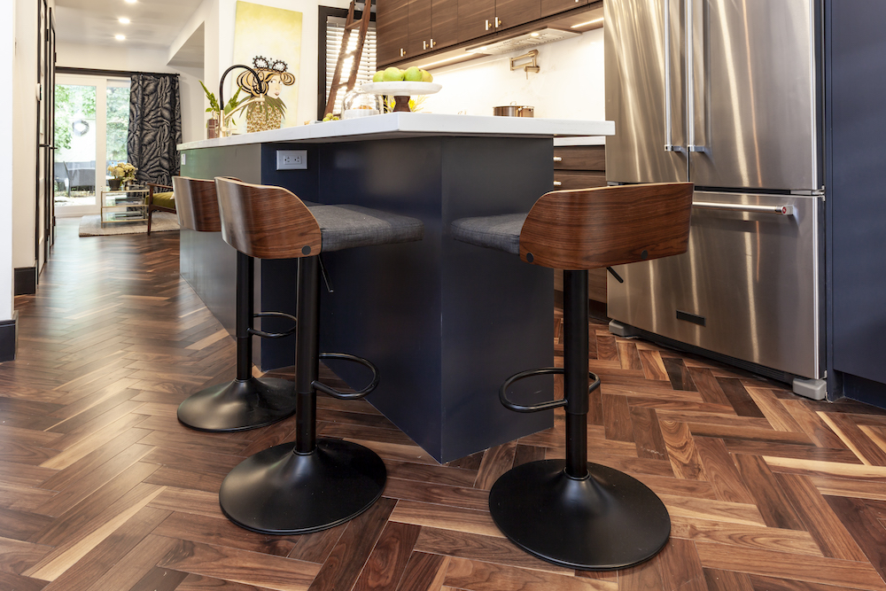 Dark wood herringbone floors run throughout a chic modern kitchen and living area