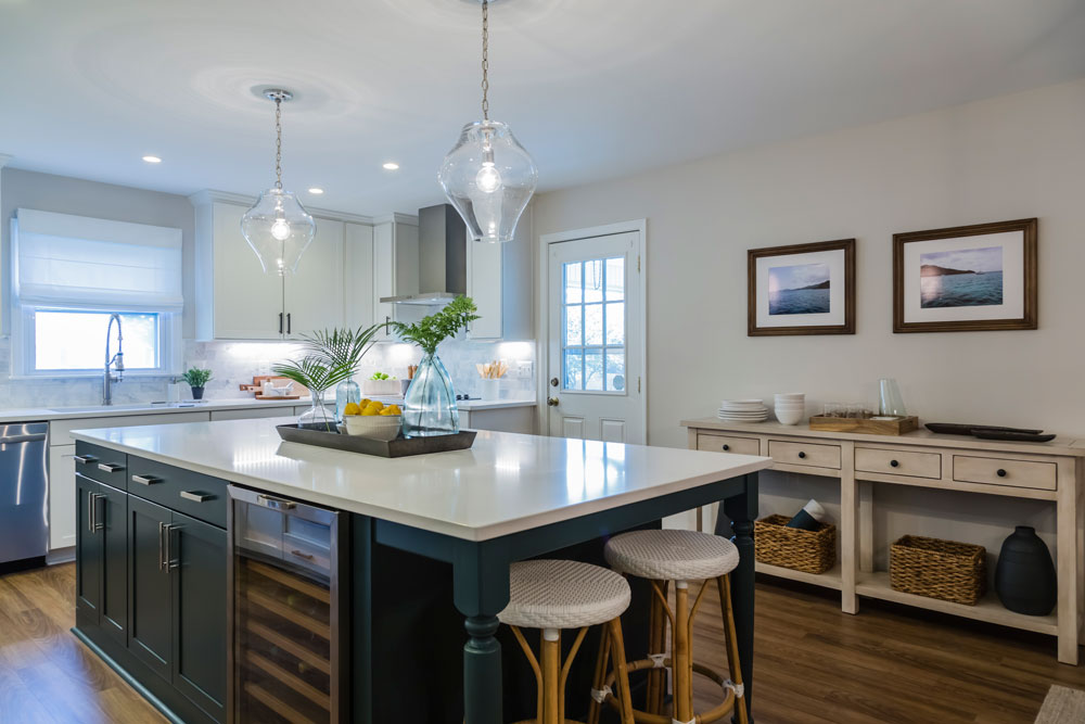 Modern farmhouse kitchen design with large navy blue island.