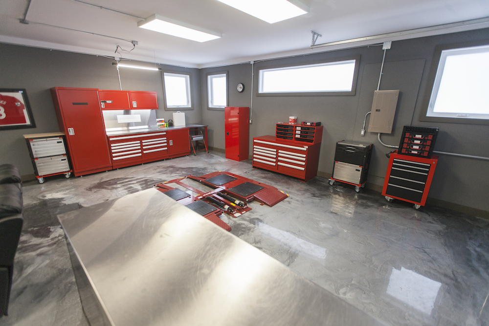 Modern garage with a car lift and red tool cabinets