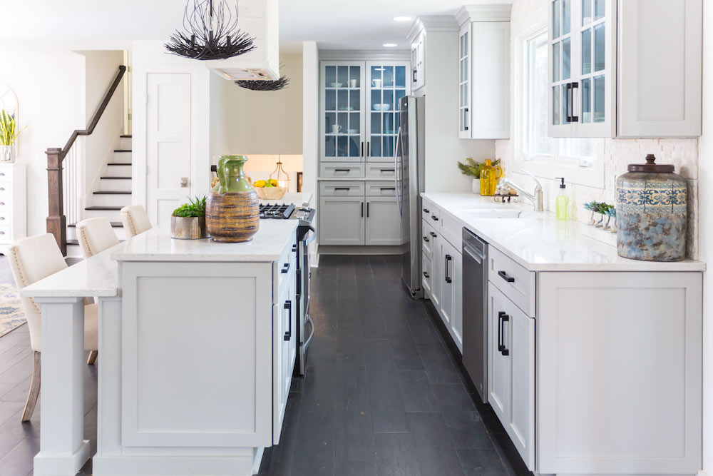 Masters of Flip split level kitchen counters and island with black flooring and white cabinets
