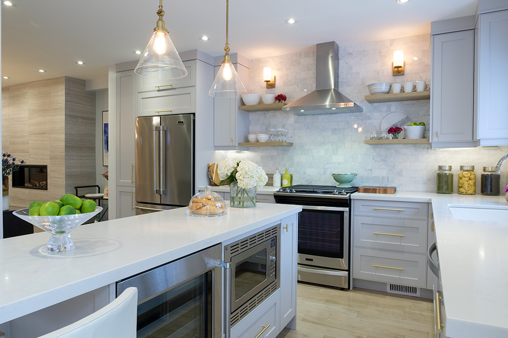 A chic white modern kitchen with a large white quartz topped centre island