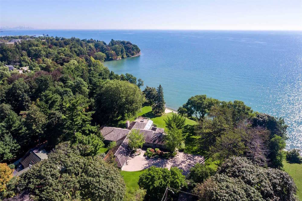 aerial view of bungalow surrounded by trees near blue water