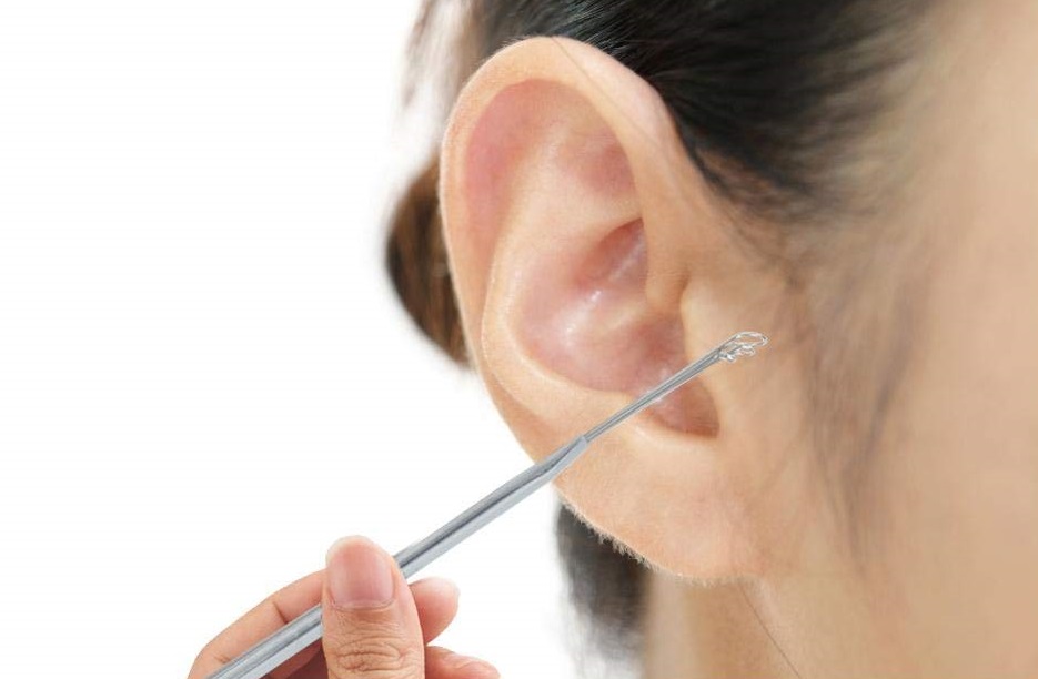 Woman using ear cleaning spoon