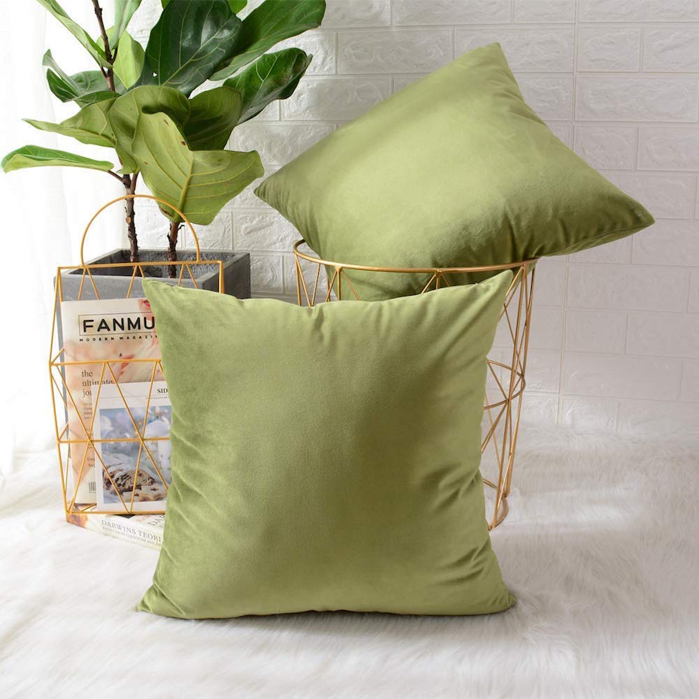 green velvet pillows and metallic baskets in white room