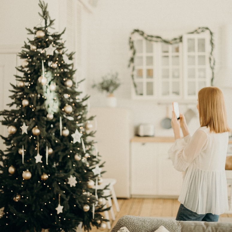 Woman taking a picture of her Christmas tree