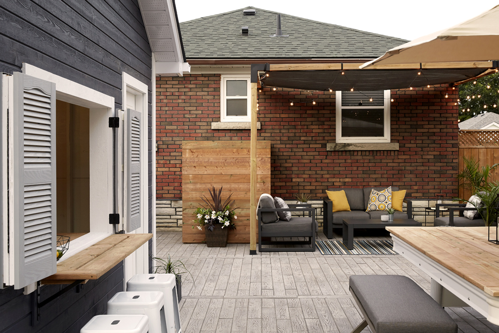 Recently renovated backyard featuring pergola with hanging lights and modern patio furniture