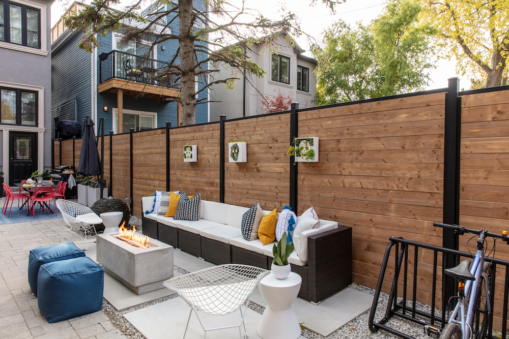 urban glam backyard lounge with concrete firepit, couch and sugar skull frames on fence