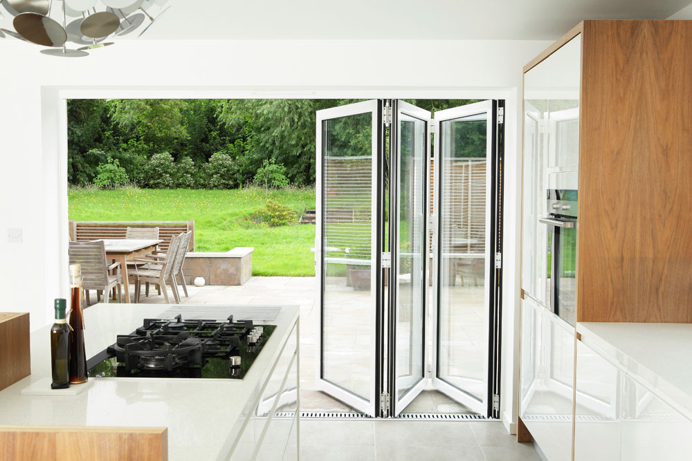 modern white kitchen with outdoor sliding doors to patio.