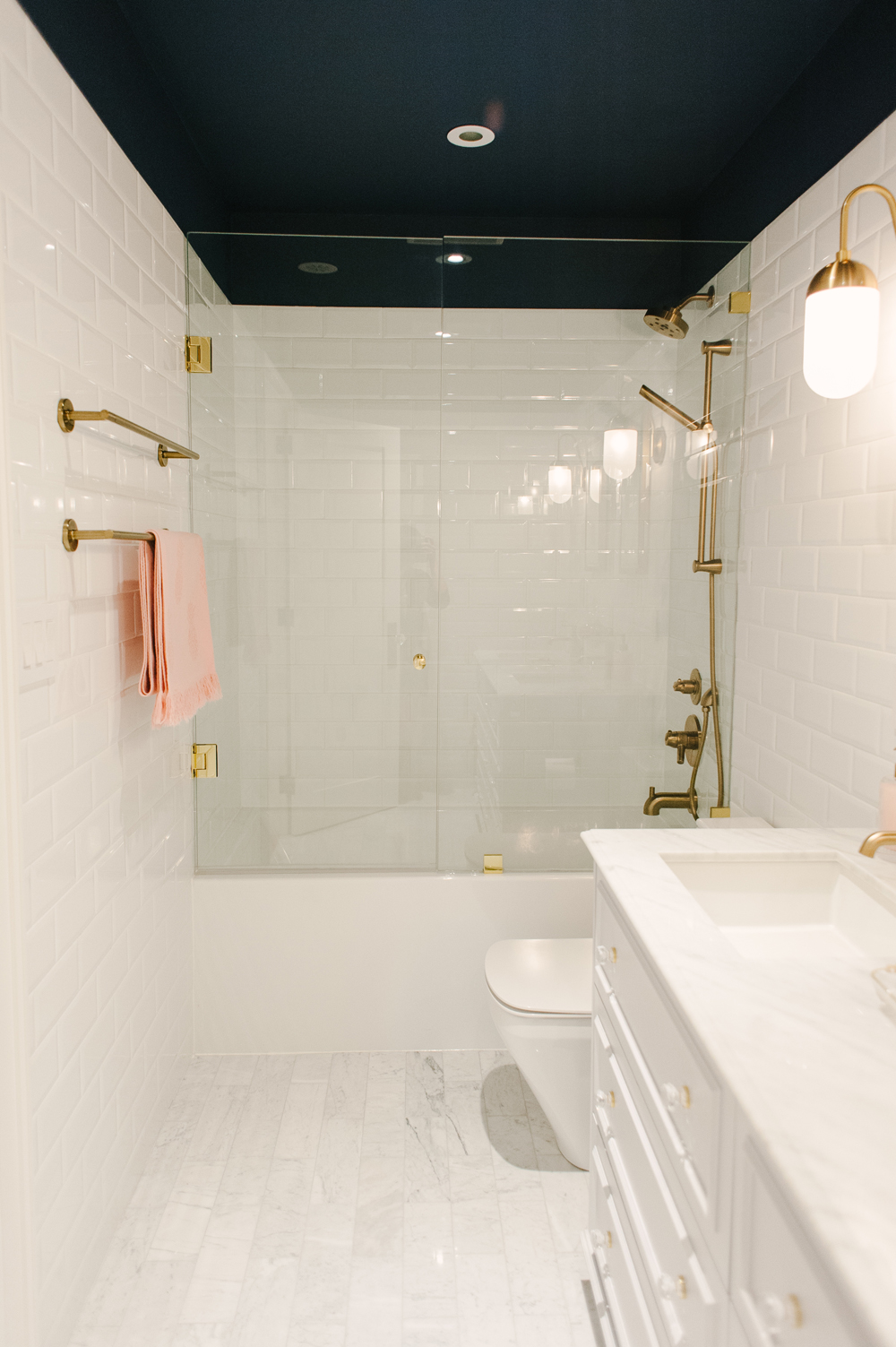 Modern white bathroom with brass fixtures.