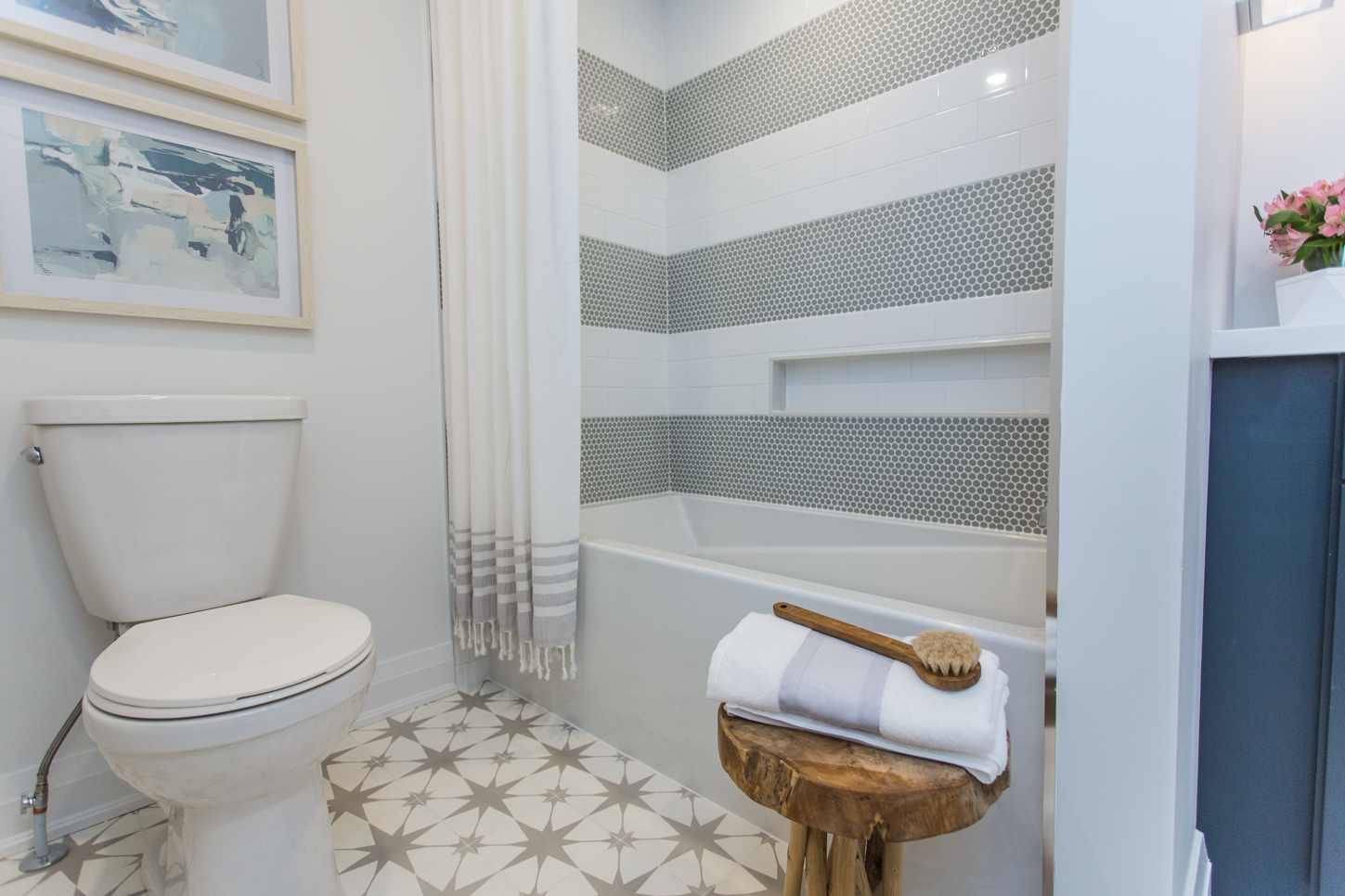 Bathroom with patterned floors and grey/white striped shower