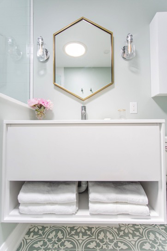 White bathroom with storage and decorative mirror