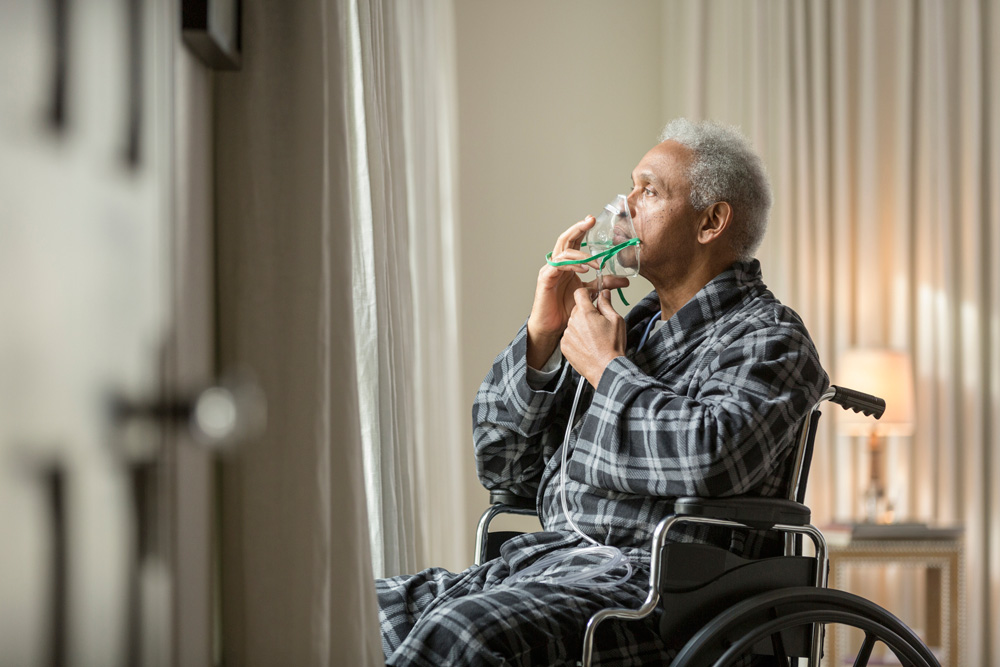 Senior with oxygen mask in a wheelchair